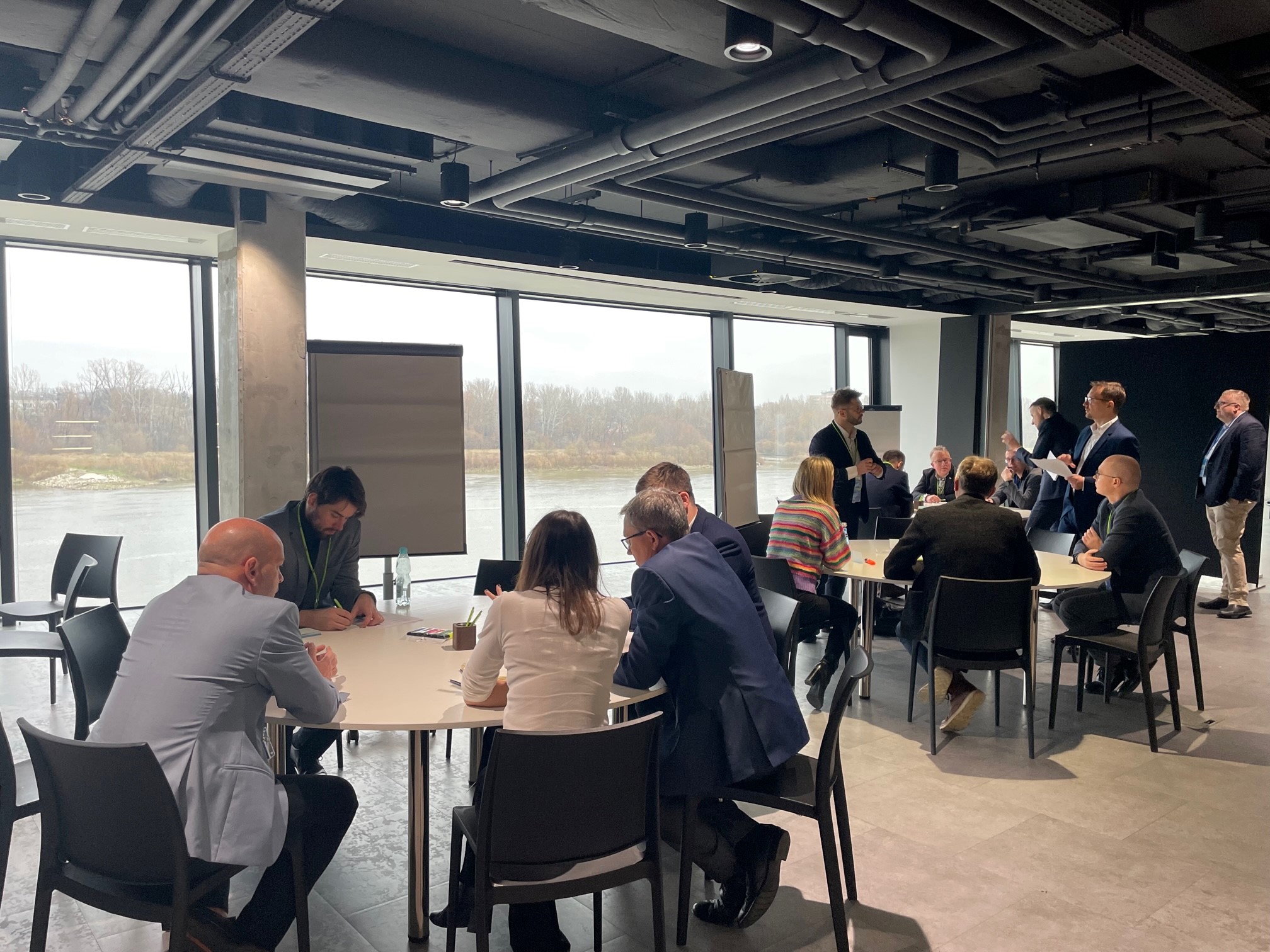 zdjęcie przedstawia kobiety i mężczyzn siedzących wokół stołów