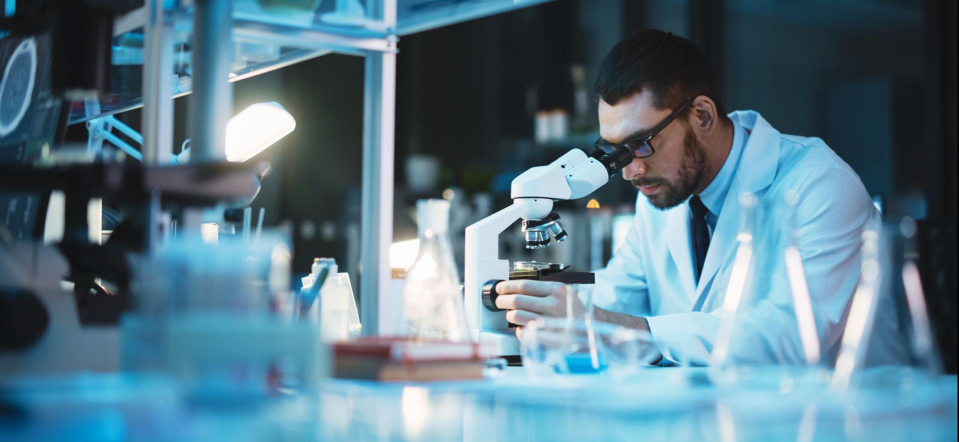 Diagnosta laboratoryjny oglądający próbkę przez mikroskop