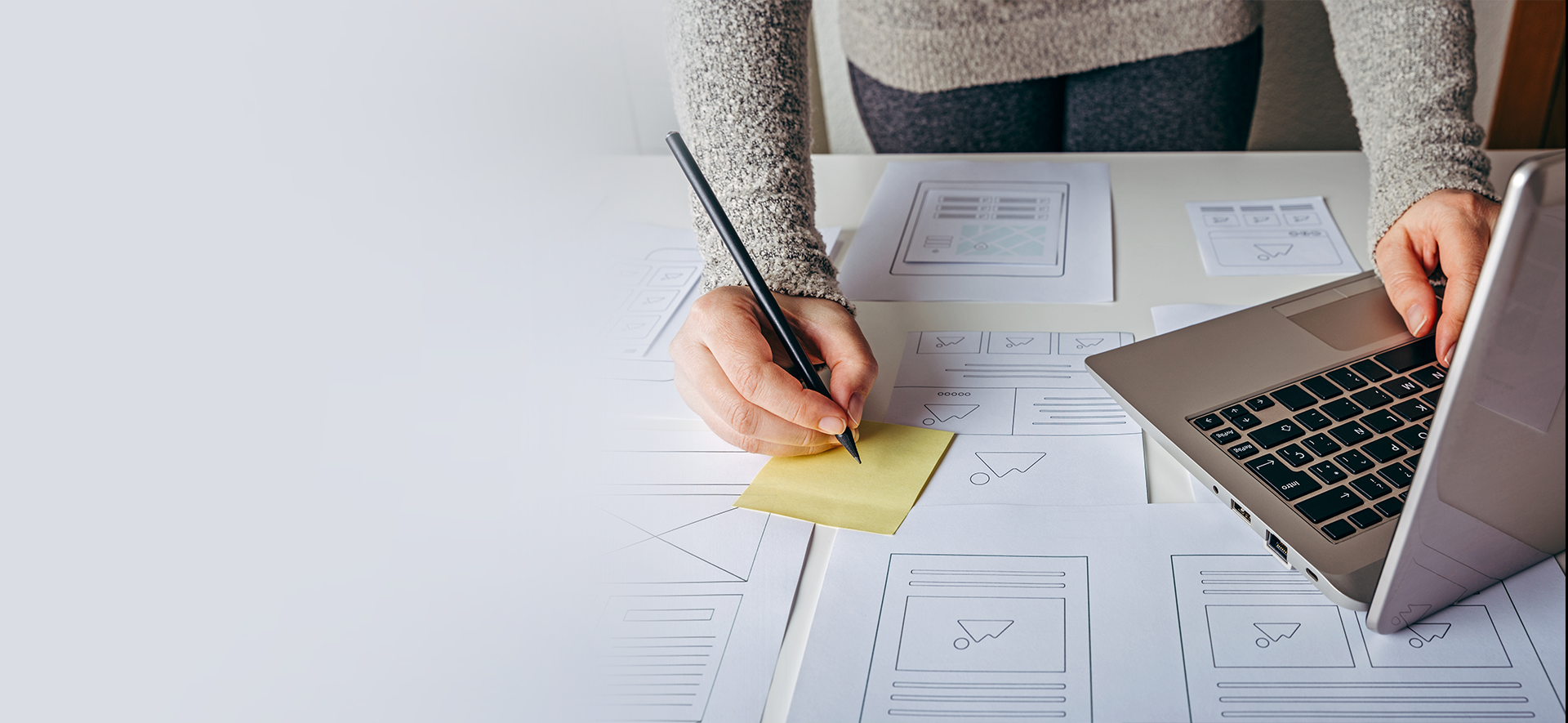 kobieta pracuje na komputerze i robi notatki na kartce