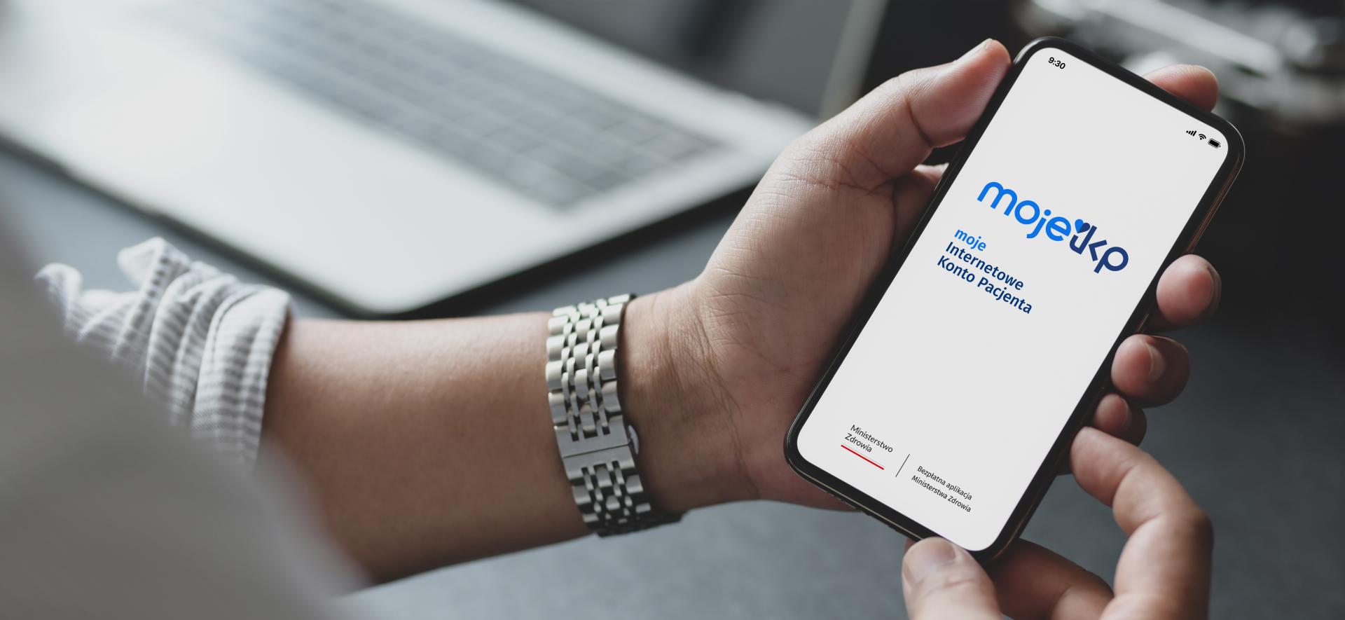 dłoń trzymające telefon, na którym wyświetla się aplikacja mojeIKP