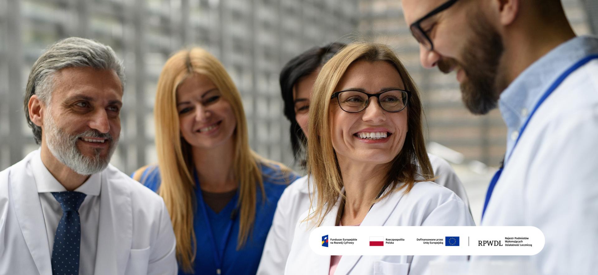 medycy patrzą się na ekran tabletu i uśmiechają się do siebie