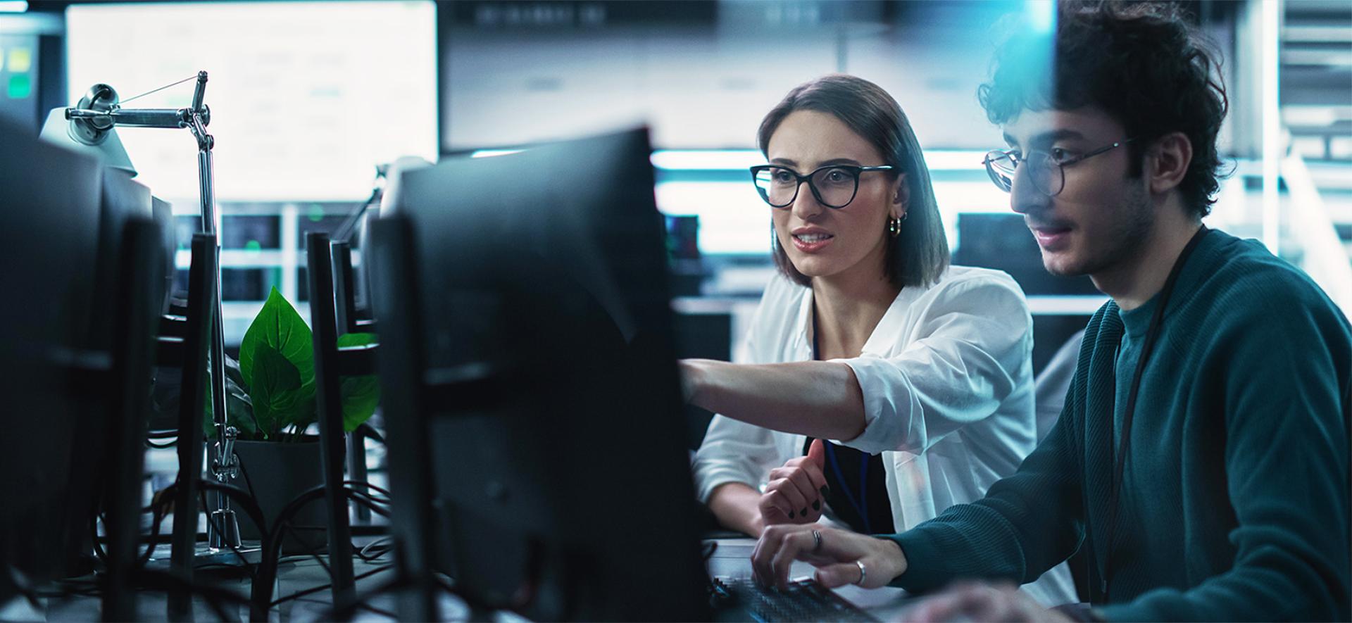 kobieta i mężczyzna pokazujący cos sobie na ekranie komputera