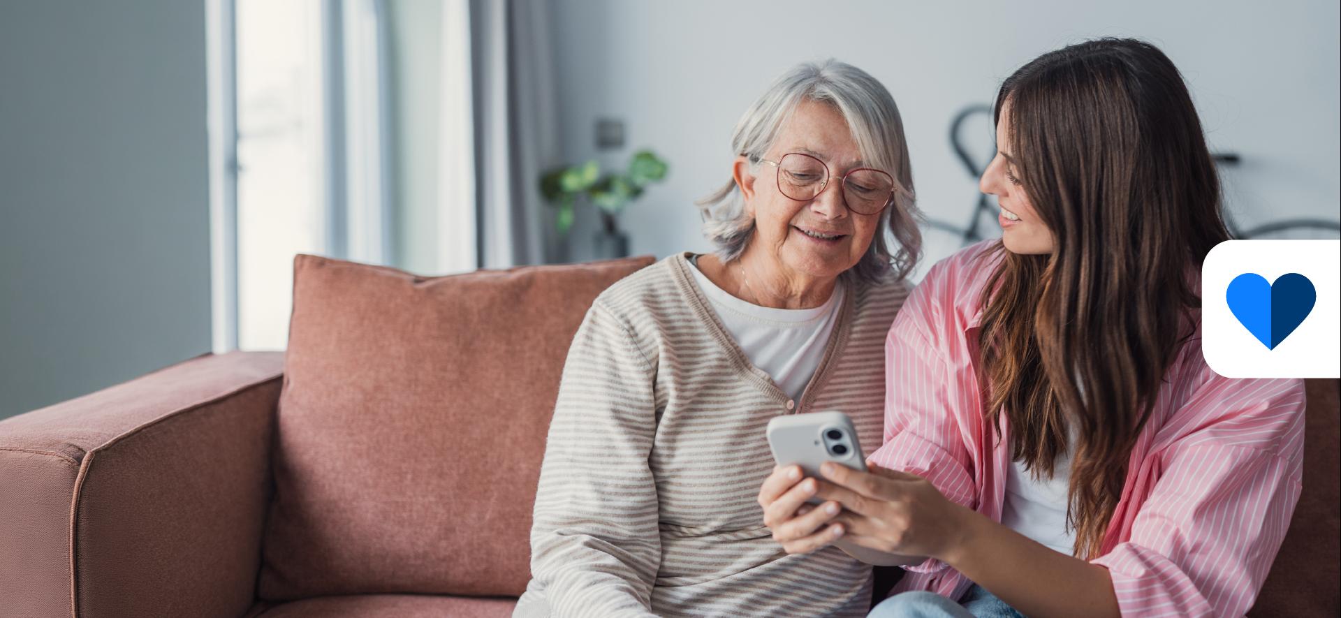 dwie kobiety patrzą na ekran smartfona