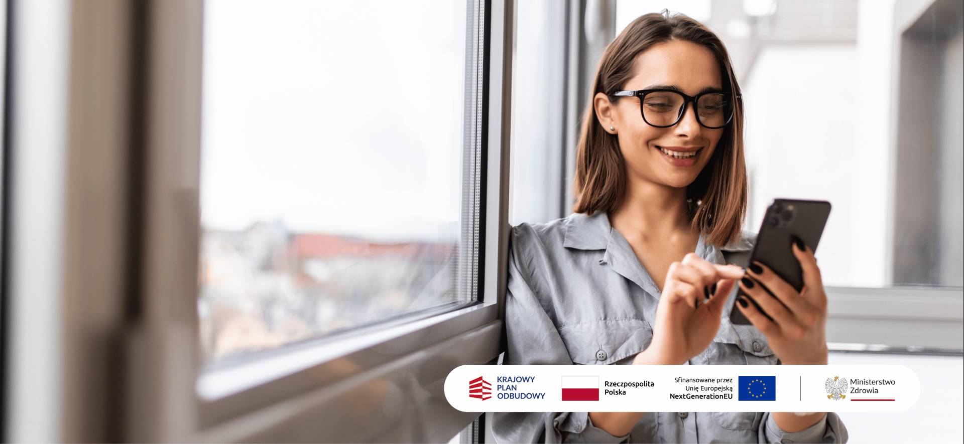uśmiechnięta kobiety patrzy na ekran smartfona