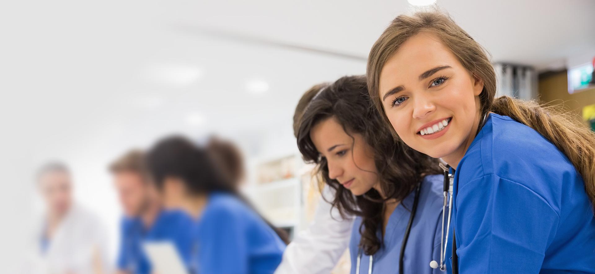 młoda lekarka uśmiechająca się i patrząca w stronę obiektywu