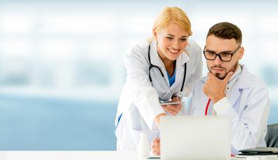 Pracownica medyczna wskazująca ekran komputera pracownikowi medycznemu