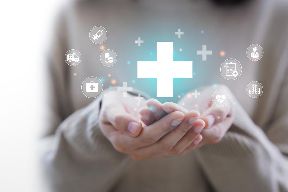 Dłoni splecione w koszyczek nad którymi unoszą się ikony związane ze zdrowiem