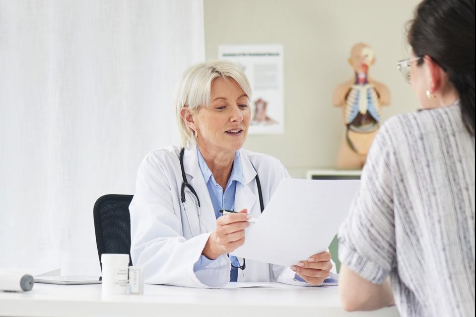 lekarka rozmawiająca z pacjentem przy biurku