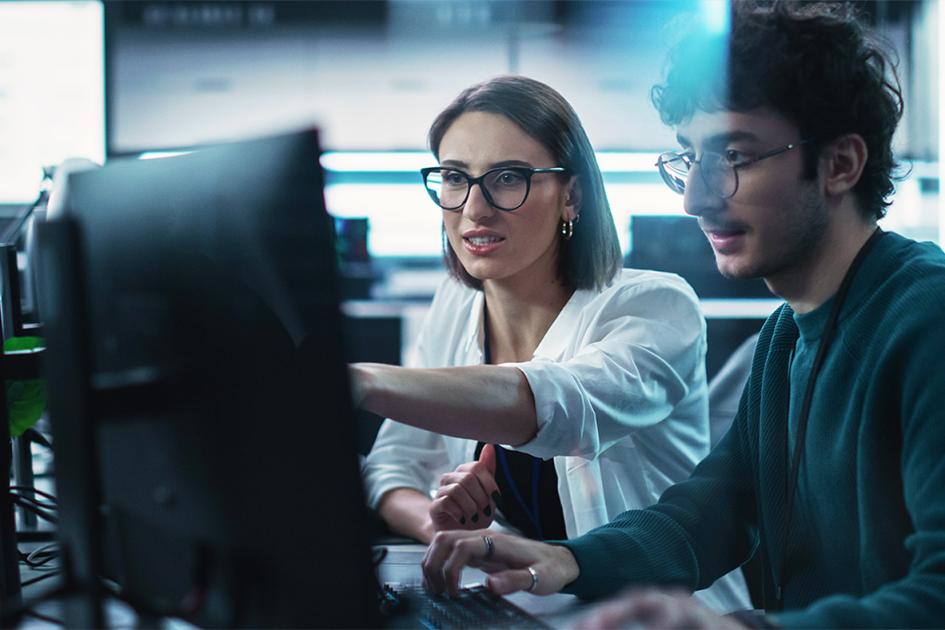 kobieta i mężczyzna pokazujący cos sobie na ekranie komputera
