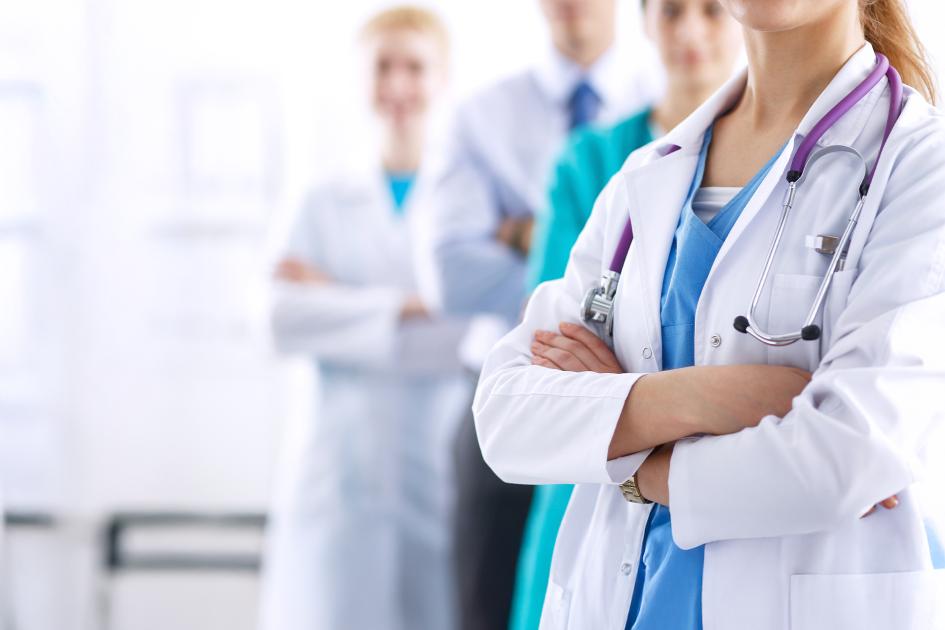 lekarze i lekarki stojący w rzędzie