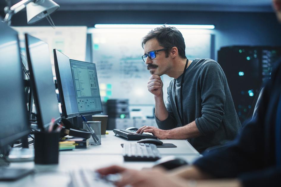 mężczyzna patrzący na monitor komputera