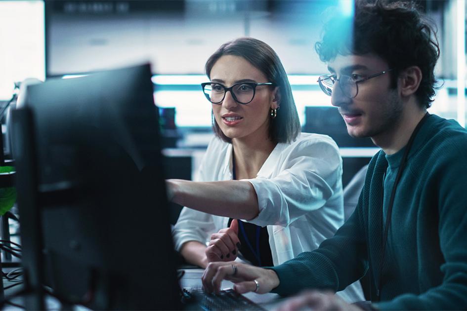 kobieta pokazuje mężczyźnie coś na monitorze, na który się patrzą