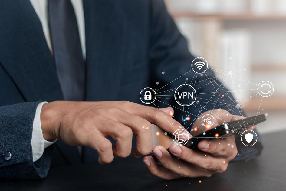 mężczyzna trzyma smartfna, z którego wyłaniają się ikony VPn i sieci
