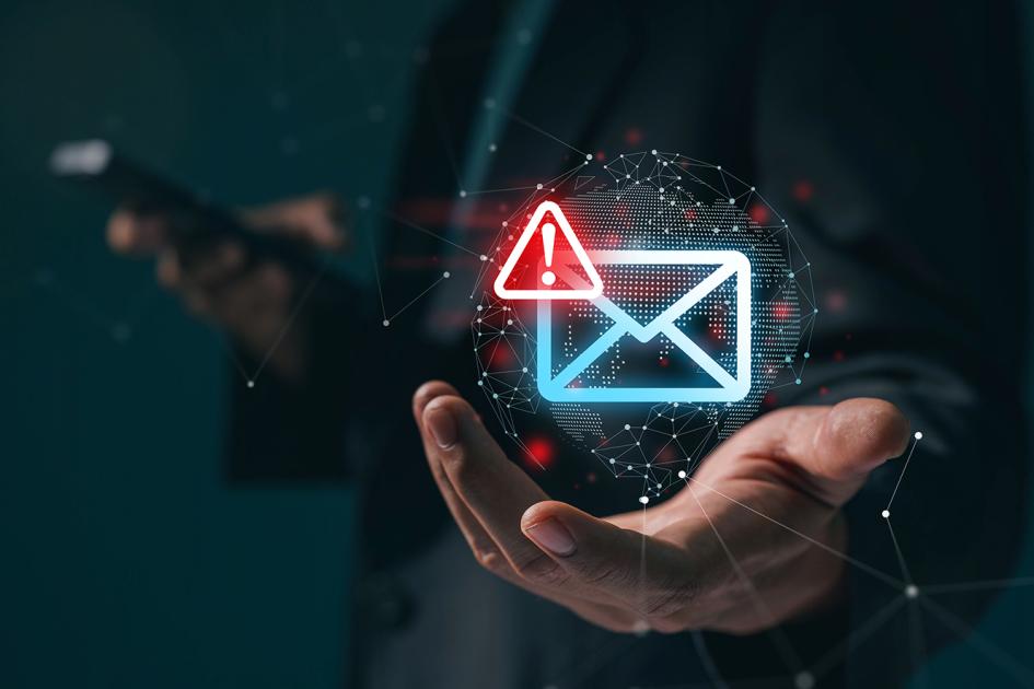 niebieski kontur koperty z czerwonym trójkątem z wykrzyknikiem unosi się nad otwartą dłonią