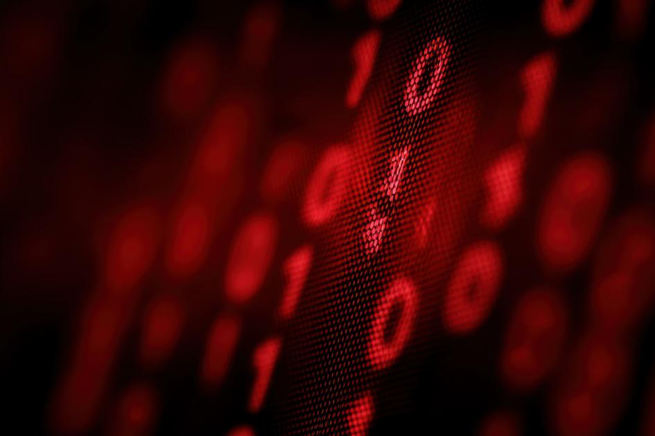 czerwone zera i jedynki w rzędach ustawionych pod skosem na czarnym tle