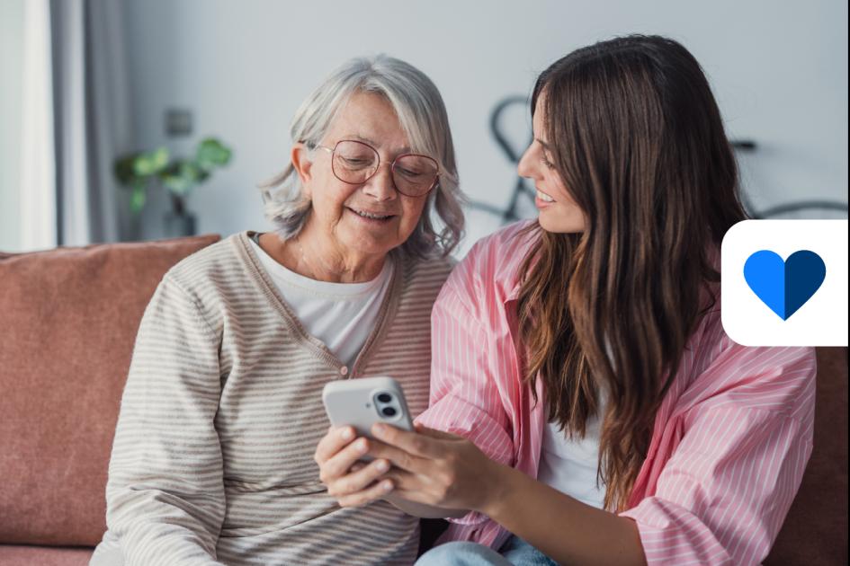 dwie kobiety patrzą na ekran smartfona