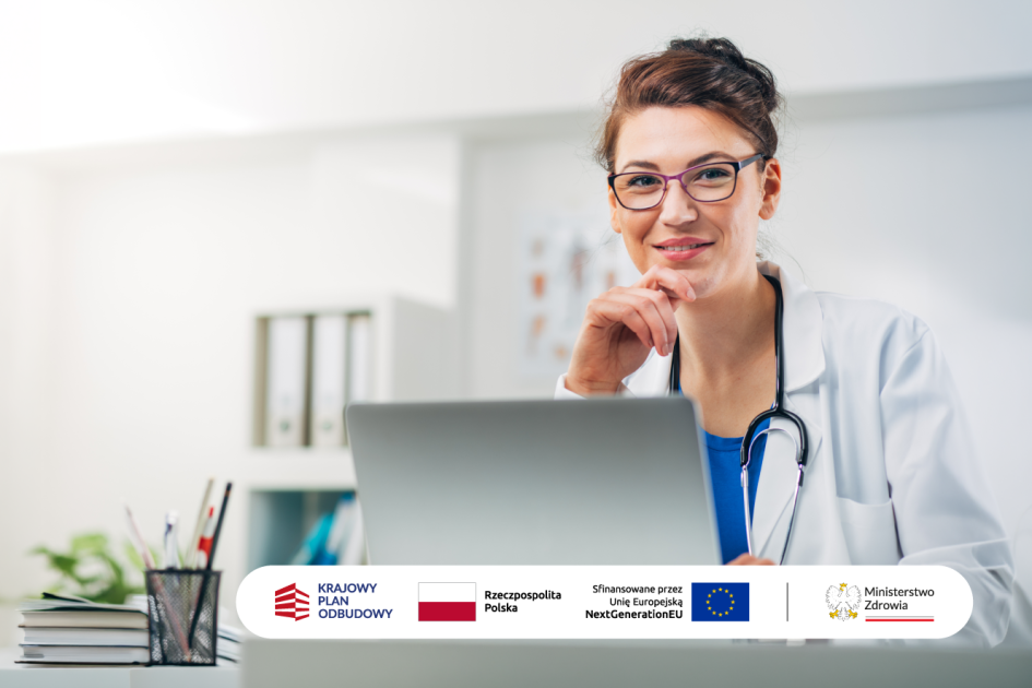 kobieta w kitlu lekarskim siedzi przed ekranem laptopa i uśmiecha się
