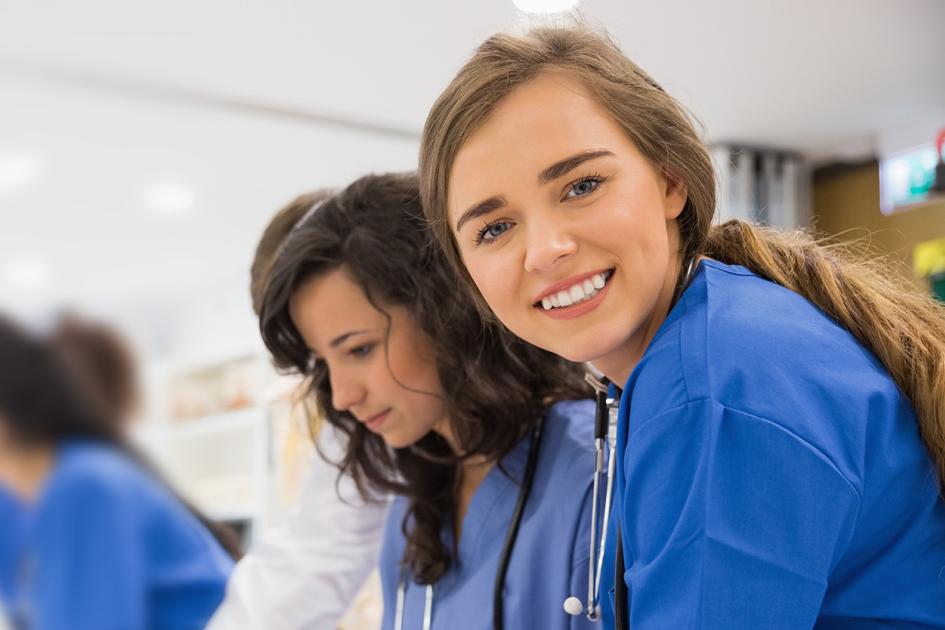 młoda lekarka uśmiechająca się i patrząca w stronę obiektywu